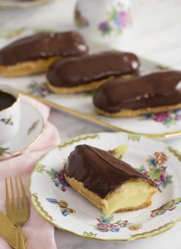 A photo of a chocolate eclair cut to expose the custard filling