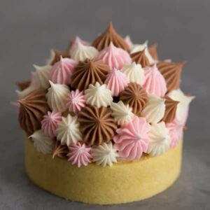 A photo of a Neapolitan tart with Swiss meringue buttercream dollops on top