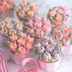 a 3/4 shot of buttercream flowers topping vanilla cupcakes.