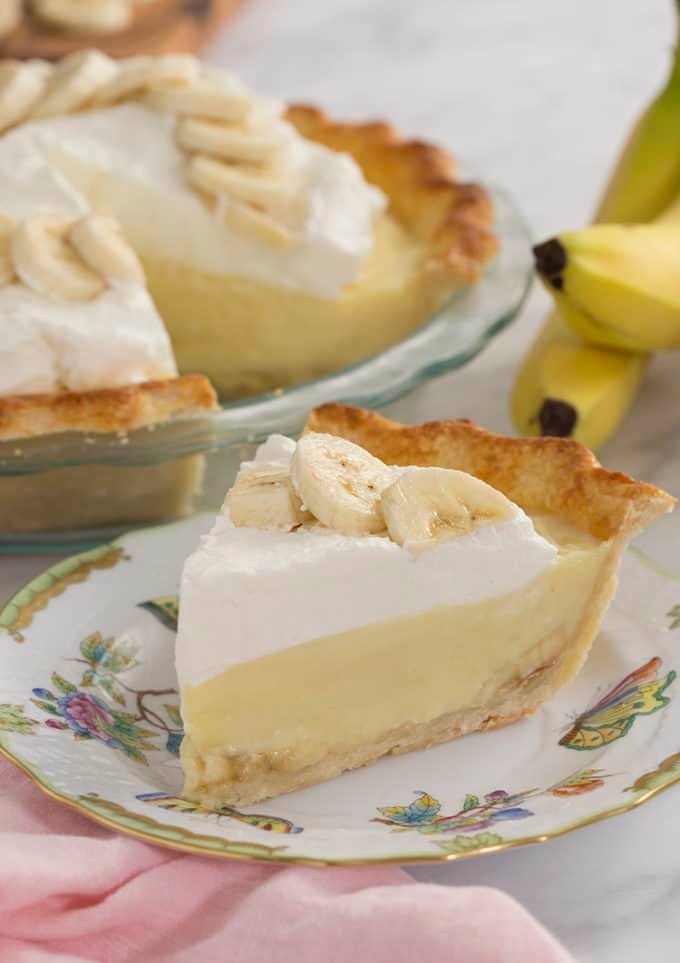 A slice of banana cream pie on a painted porcelain plate