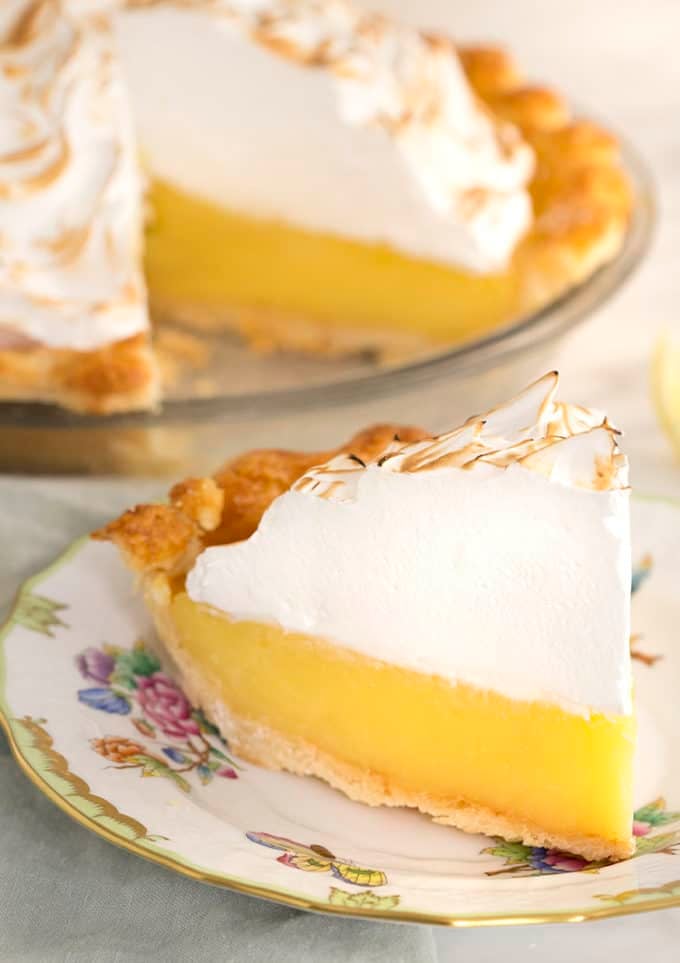 A slice of lemon meringue pie on a porcelain plate.