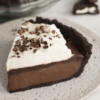 A piece of chocolate mud pie topped with whipped cream on a plate