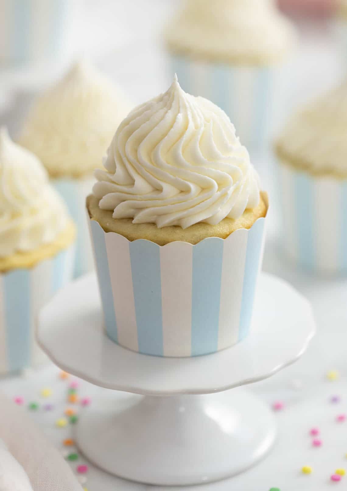 piping frosting on cupcakes