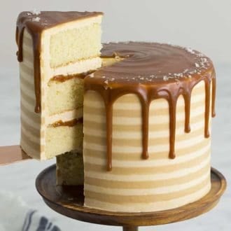 A salted caramel cake with stripes and a caramel drip on top
