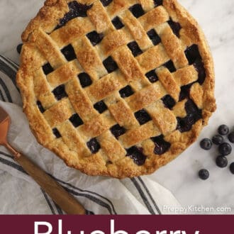 blueberry pie on a counter with blueberries scattered
