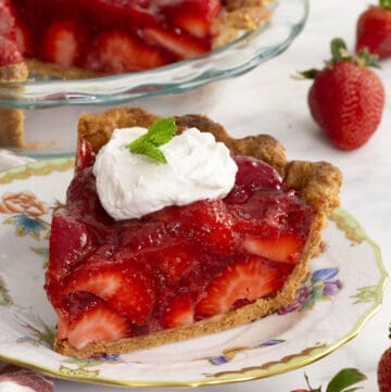 A piece of strawberry pie on a porcelain plate.