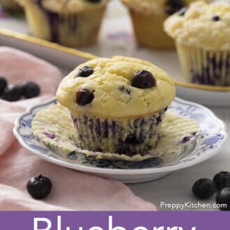 Pinterest graphic of a plate with a blueberry muffin with the liner pulled down. Three more muffins in the background.