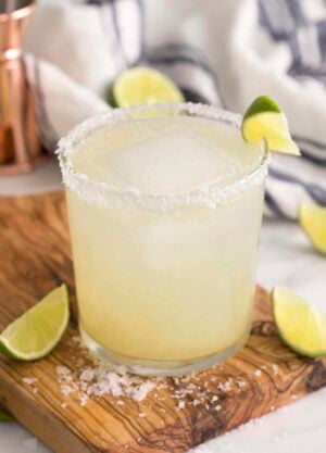 A from-scratch margarita in a tumbler garnished with a lime wedge.