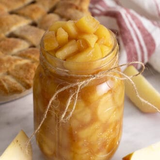 A glass mason jar full of apple pie filling