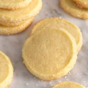 Butter cookies on a white marble table with sugar scattered around