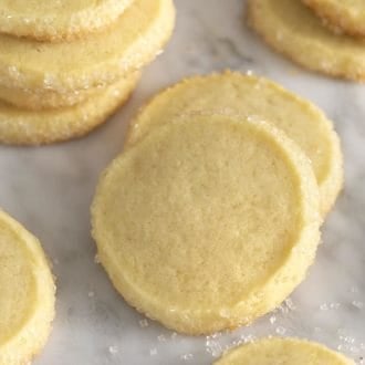 Butter cookies on a white marble table with sugar scattered around