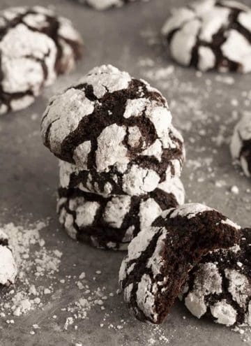 A stack of chocolate crinkle cookies on a grey surface
