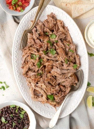 An overhead shot of instant pot pulled pork on a white platter