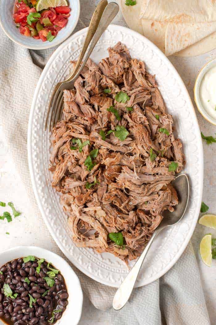 An overhead shot of instant pot pulled pork on a white platter