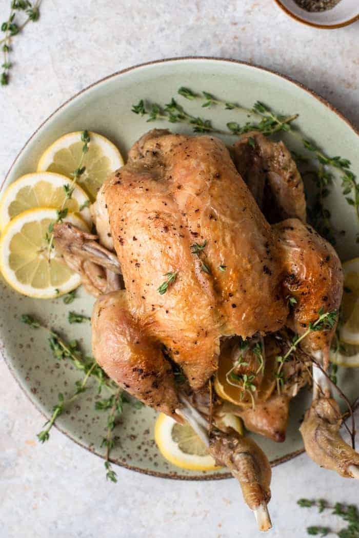 An overhead shot of instant pot whole chicken on a plate with crispy skin
