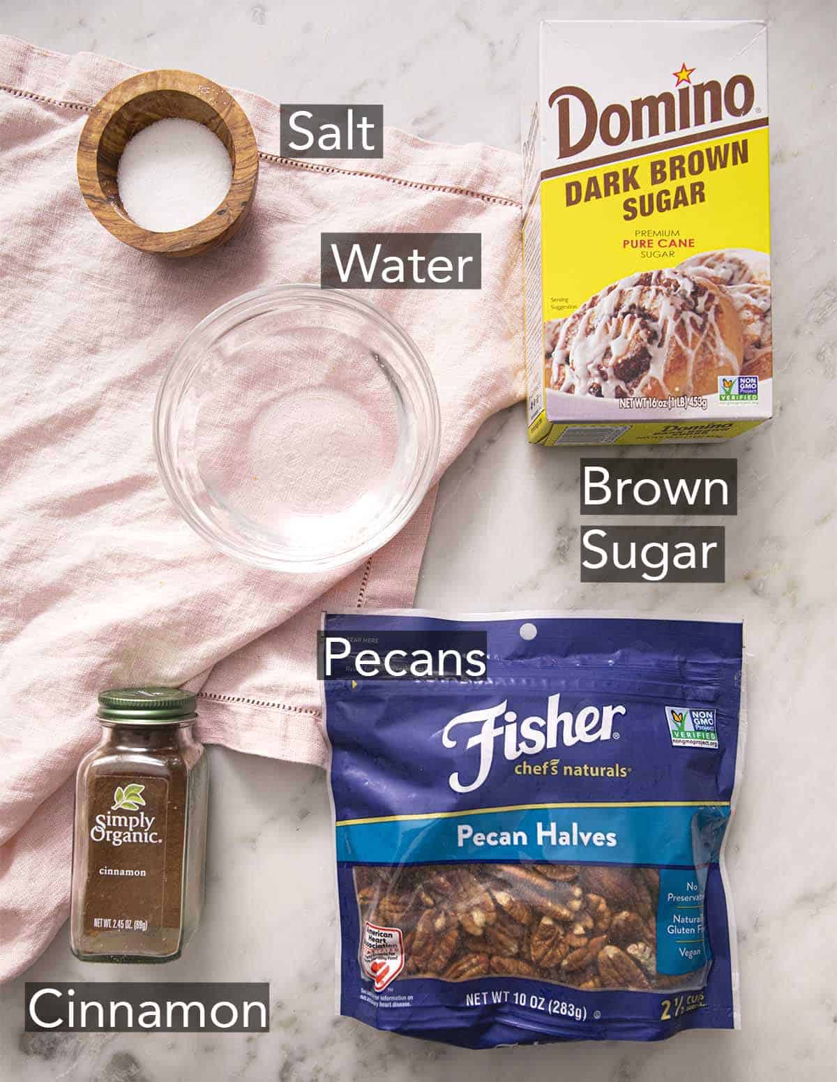 Ingredients to make candied pecans laying on a marble counter.