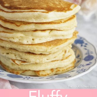 tall stack of fluffy pancakes on a plate with butter