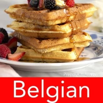 stack of belgian waffles topped with berries on a plate