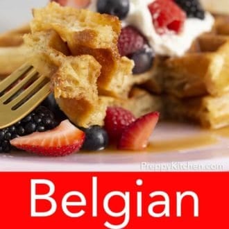 stack of belgian waffles topped with berries on a plate