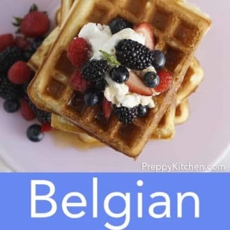 stack of belgian waffles topped with berries on a plate