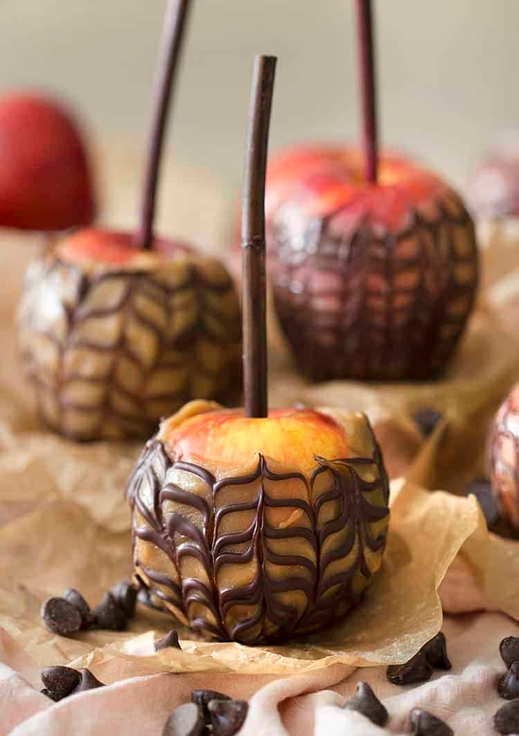 A group of caramel apples striped with chocolate