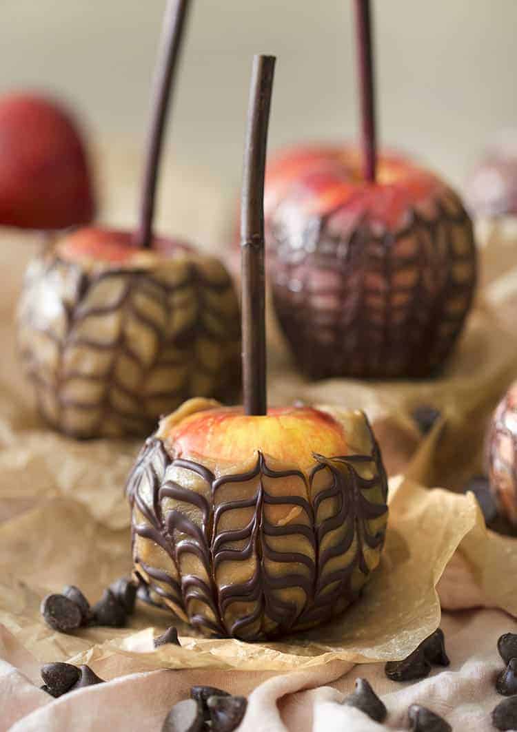 A group of caramel apples striped with chocolate