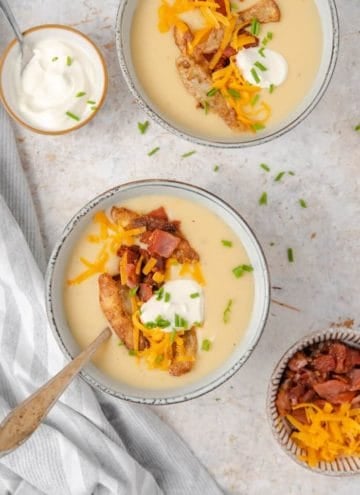 An overhead shot of potato soup in two bowls