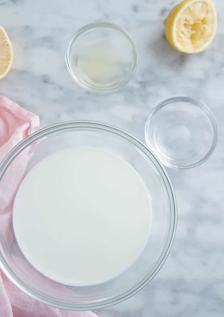 Bowls of milk, viinegar and lemon juice on a marble table.