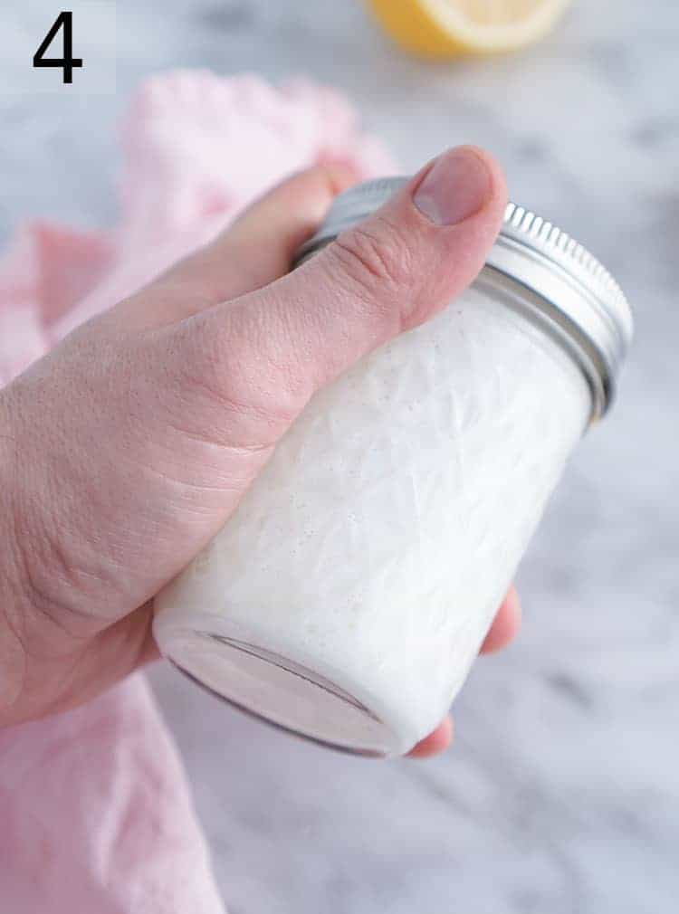 Buttermilk substitute being made by shaking milk and vinegar in a mason jar.