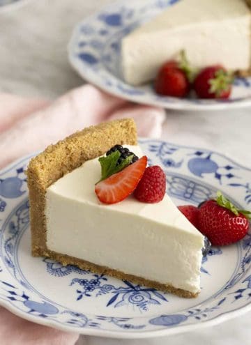 Slices of no bake cheesecake blue and white dishes with berries.