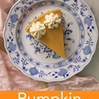 A piece of pumpkin cheesecake with dollops of whipped cream on a blue and white plate.