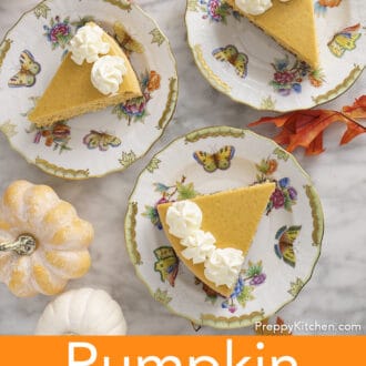 Three pieces of pumpkin cheesecake with whipped cream on plates.