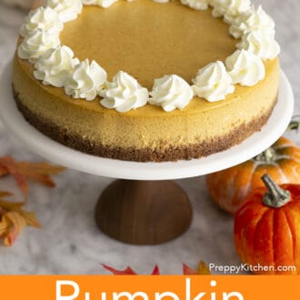 A pumpkin cheesecake with whipped cream on a cake stand.