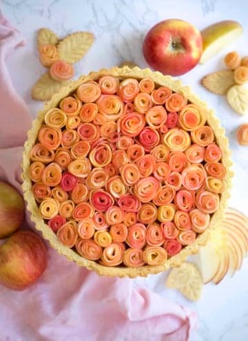 A photo of an apple rose tart on a marble table.