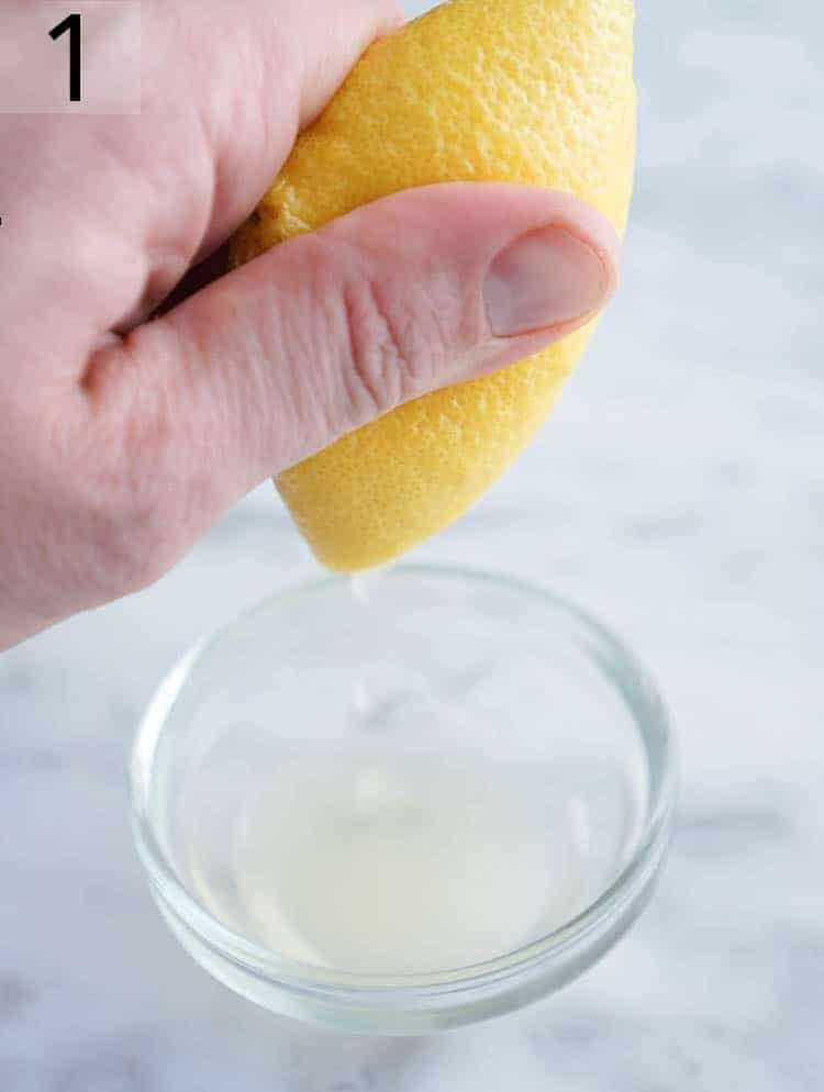 Lemon juice being squeezed into a small bowl.