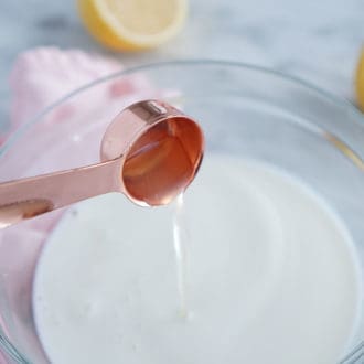 Vinegar pouring into milk to make buttermilk.