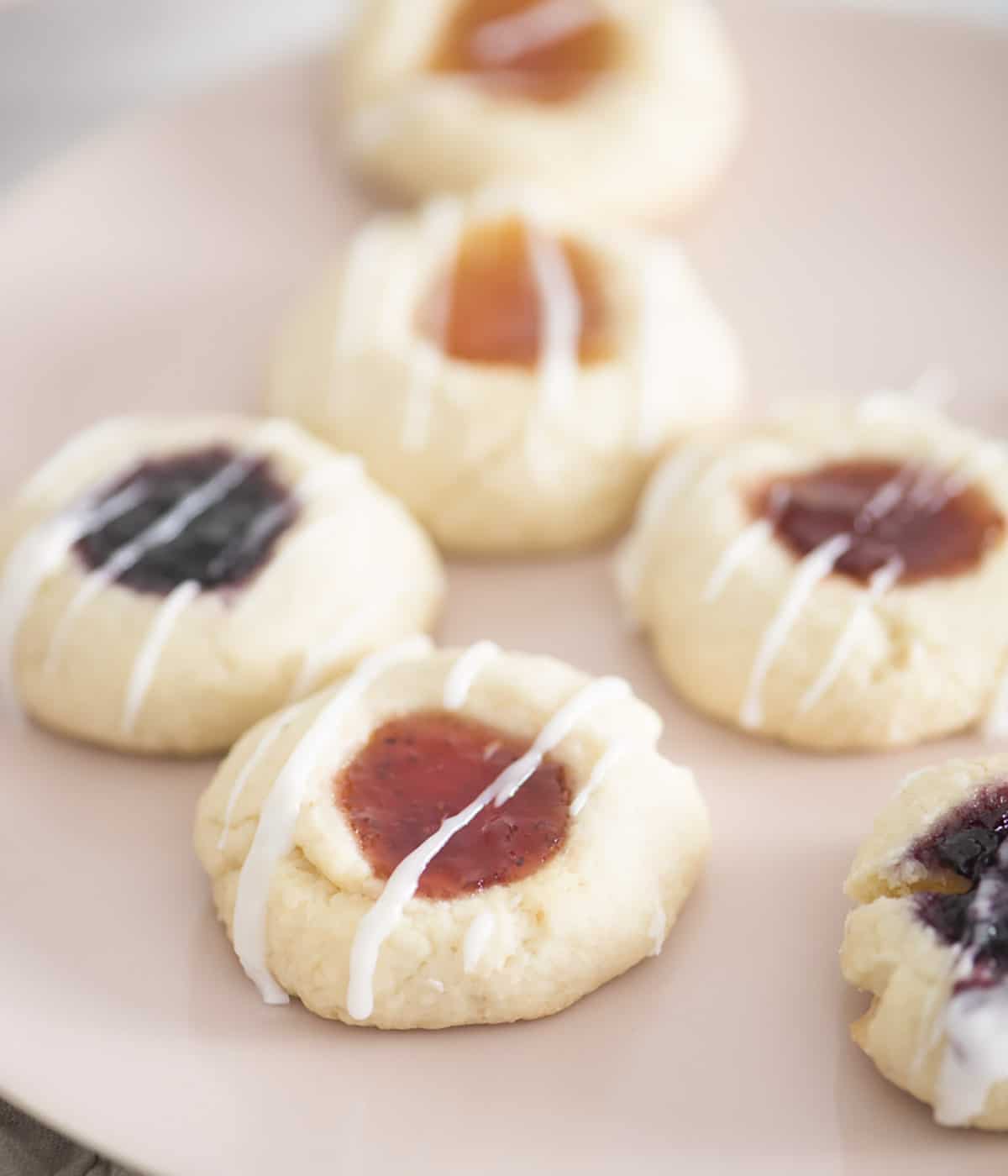 Thumbprint cookies on a soft pink plate.