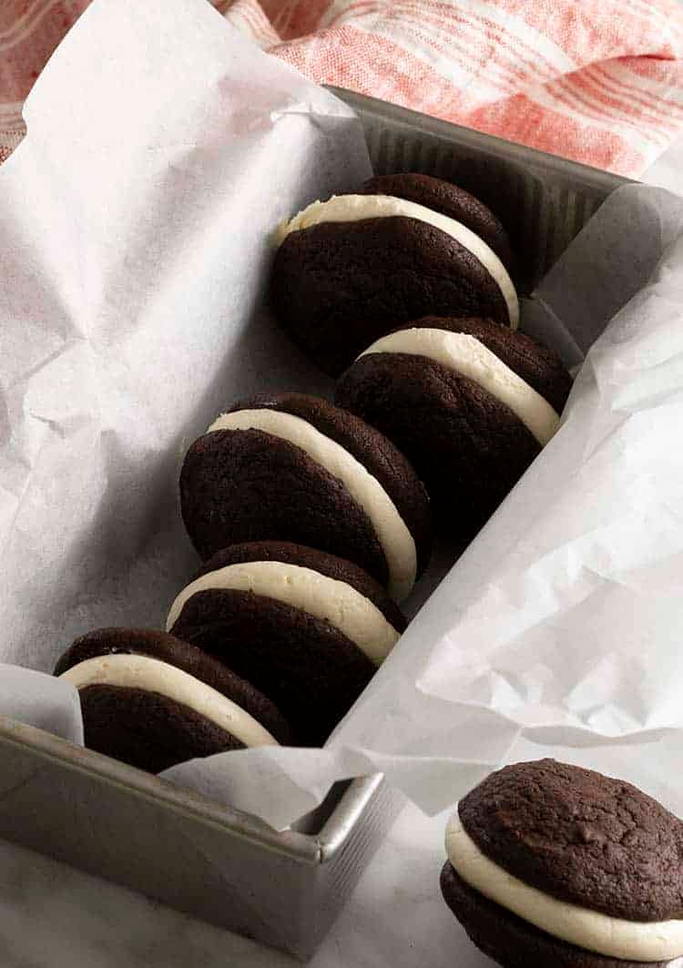 Whoopie pies in a container with parchment paper.