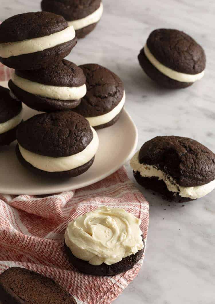 A group of whoopie pies on a white marble table.