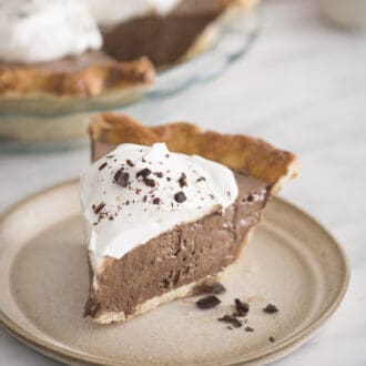 A piece of chocolate pie with whipped cream and shaved chocolate..