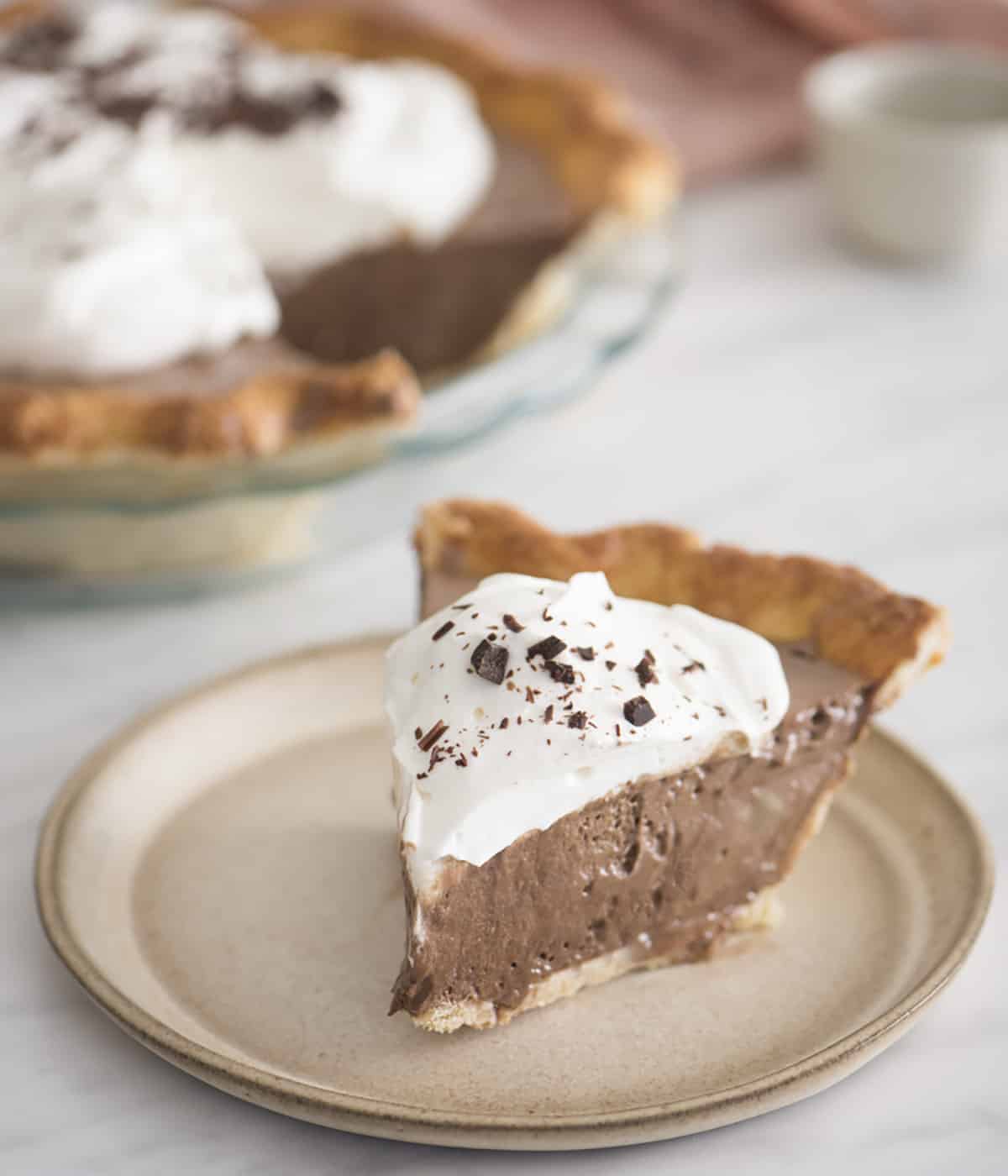 A piece of chocolate pie topped with whipped cream and shaved chocolate.