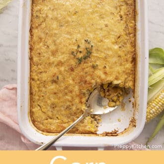 Corn Casserole getting served from a baking dish with a gold spoon.