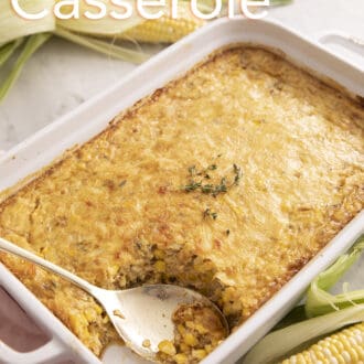 A corn casserole topped with baked cheese and some fresh thyme.