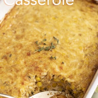A closeup photo of corn casserole in a white baking dish.