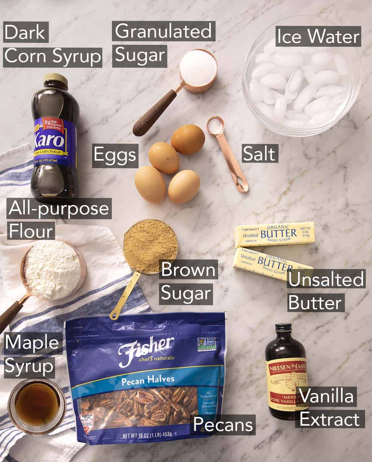 Ingredients for making pecan pie on a marble counter.