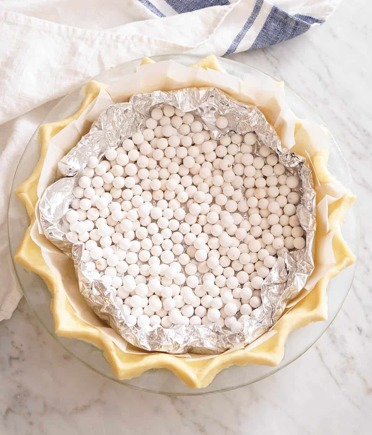 An unbaked pie crust filled with foil and baking weights.