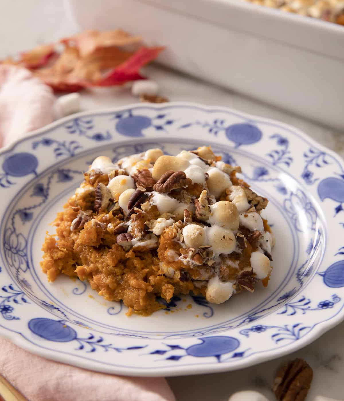 A portion of sweet potato casserole on a blue and white plate.
