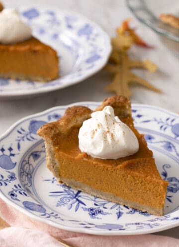 A piece of sweet potato pie on a blue and white plate.