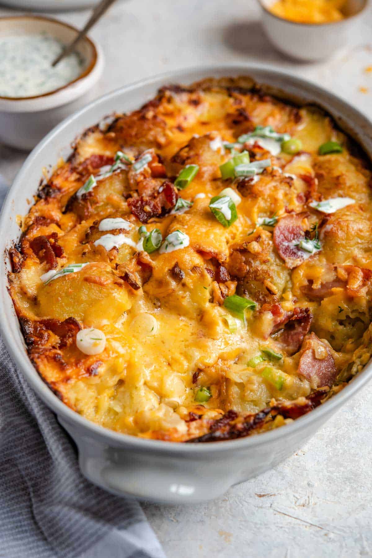 A close up of a cheesy tater tot casserole in a baking dish