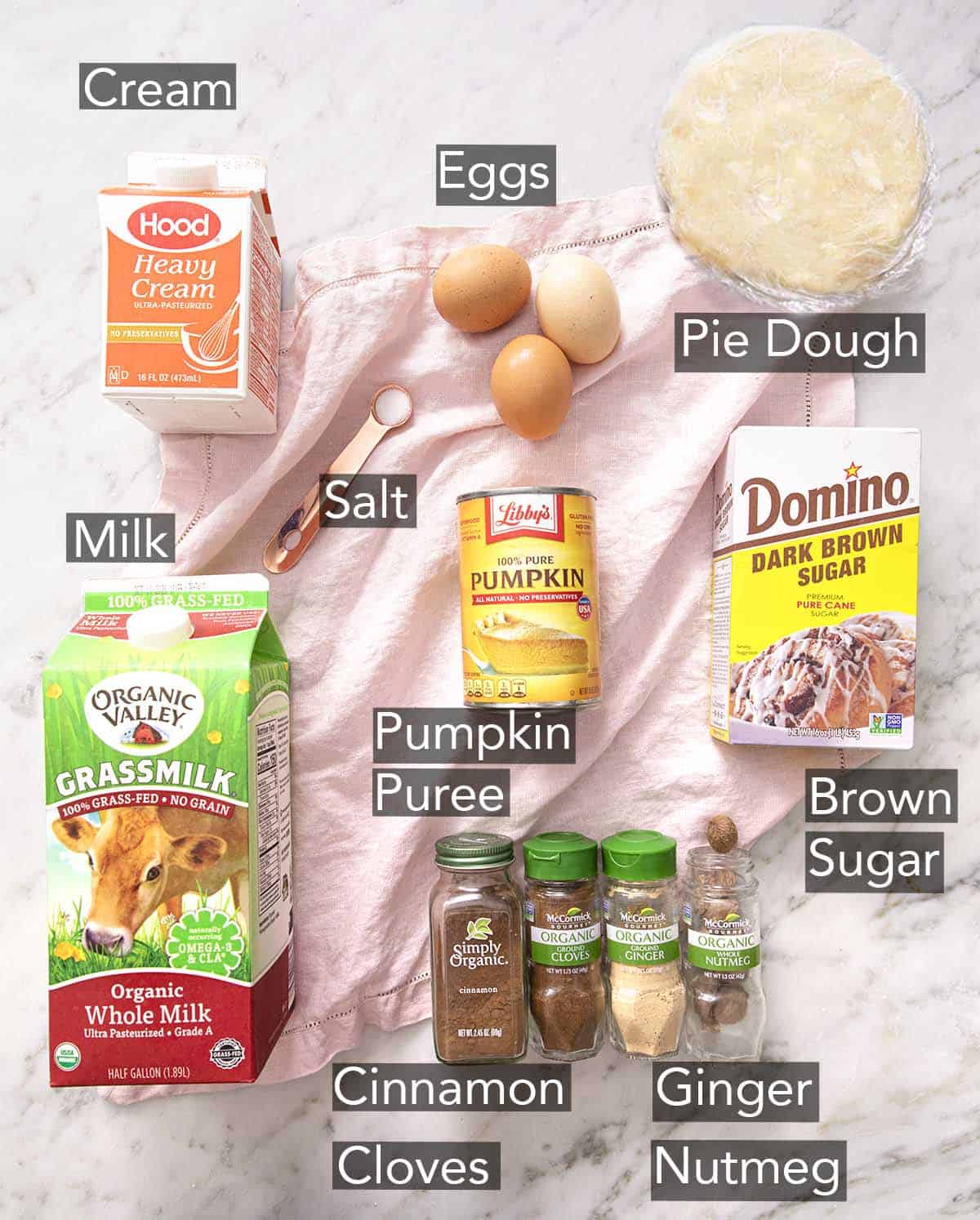 Ingredients to make Pumpkin pie on a marble counter.